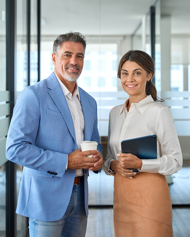 Portrait of two happy executives business man and woman partners in office.