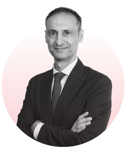 Retrato corporativo de Víctor Correa, posando de brazos cruzados con traje formal.